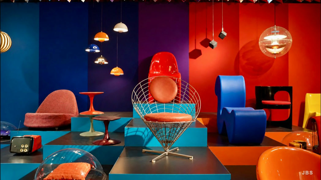 Colorful modern chairs and pendant lights arranged against saturated walls