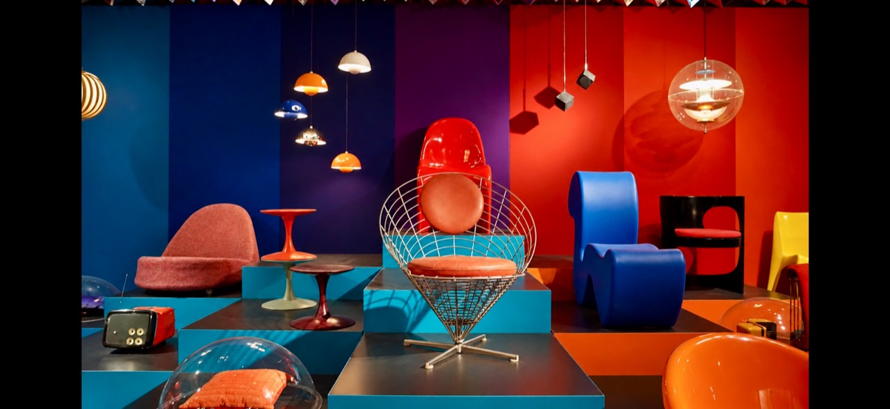 Colorful modern chairs and pendant lights arranged against saturated walls