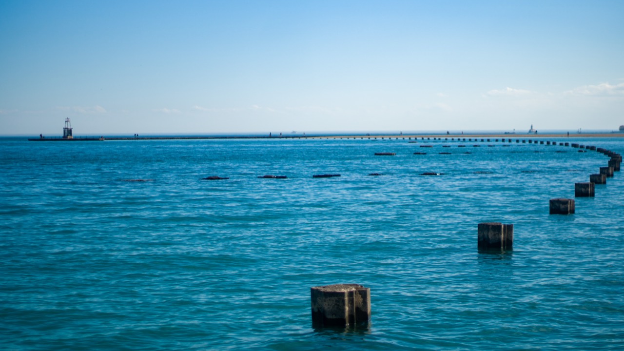 Rows of weathered pilings receding across bright blue water