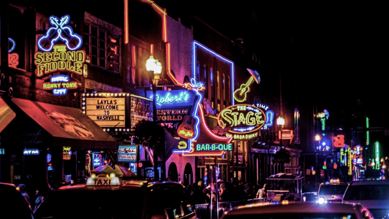 Neon signs illuminating a crowded city street at night