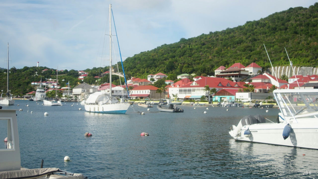 Sailboats resting off the red-roofed waterfront of Gustavia