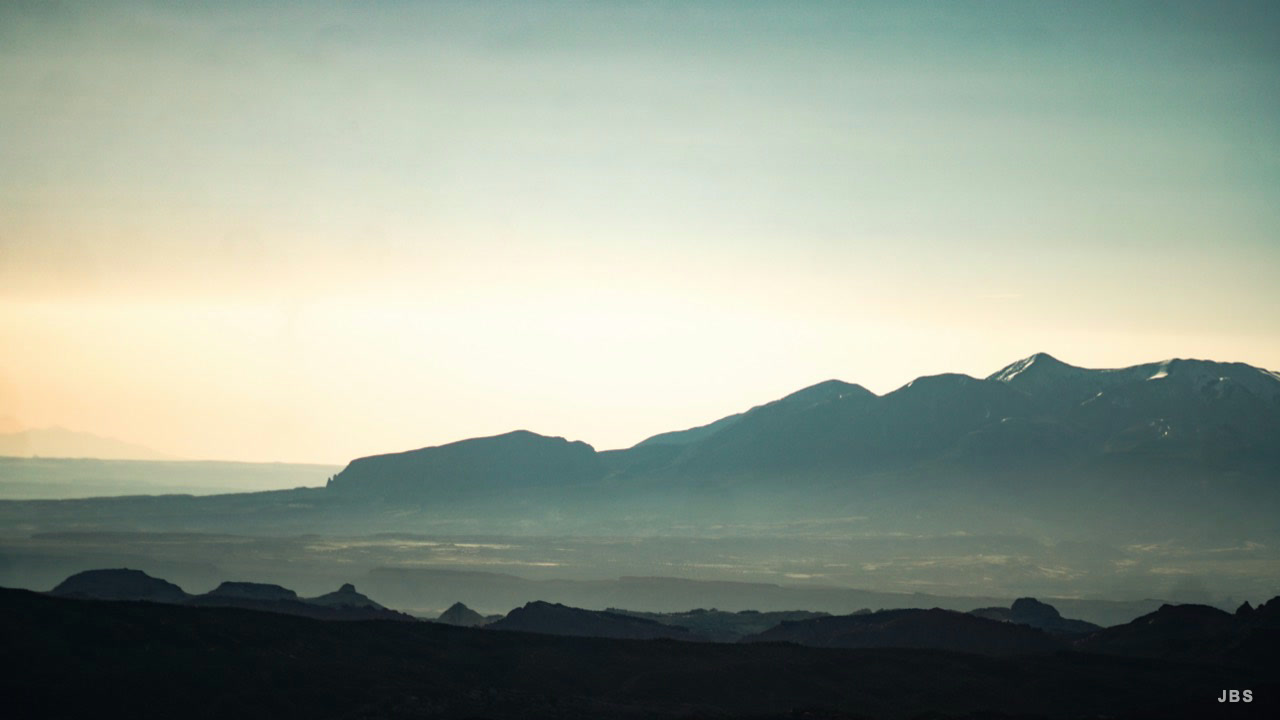 Layers of western mountains fading into pale evening light