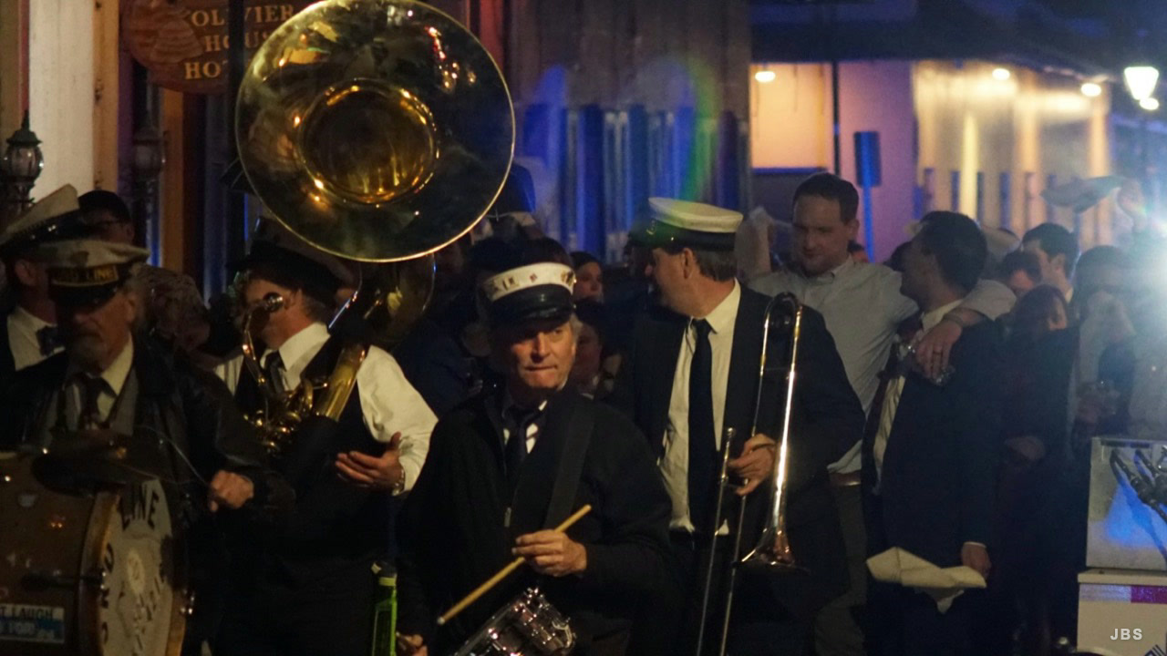 A brass band playing at night in a crowded New Orleans street